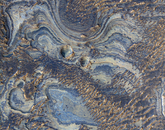Multicolored layers with two round depressions near the center. Along the plateau to the southwest of Melas Chasma, layers with many colors and variable brightness delight the eye. The strata may have formed by deposition from the wind, volcanism or water activity. Dunes that eroded into strange shapes cover some of the strata.